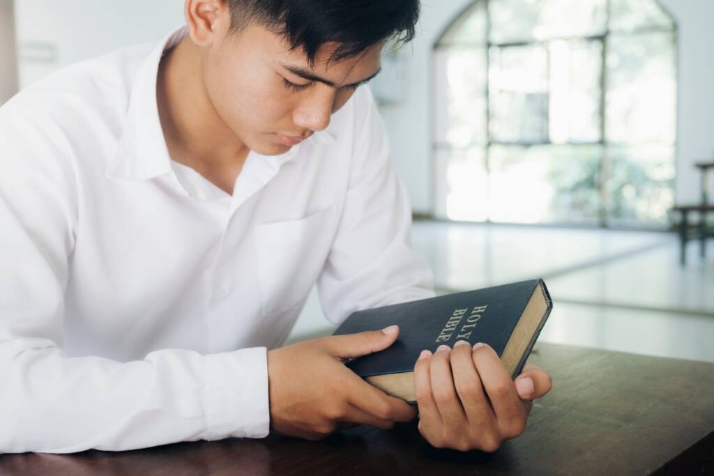 Man holding the holy book, an Asian student